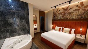 Ein modernes Hotelzimmer mit einem großen Bett, einem separaten Badezimmer mit Whirlwanne und einem dekorativen Wandbild.