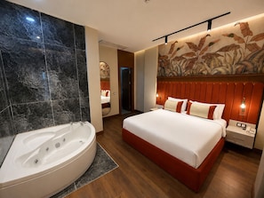 Een moderne hotelkamer met een groot bed, een aparte badkamer met een whirlpool en een decoratief behang.