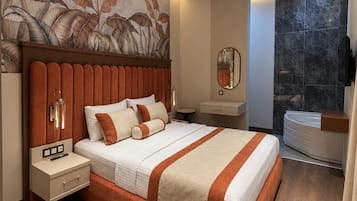 Un dormitorio moderno con una cama grande, una mesita de noche, un espejo, un tocador y un baño con bañera.