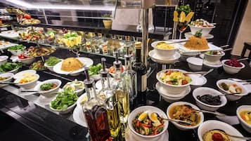 A buffet with various dishes and condiments.