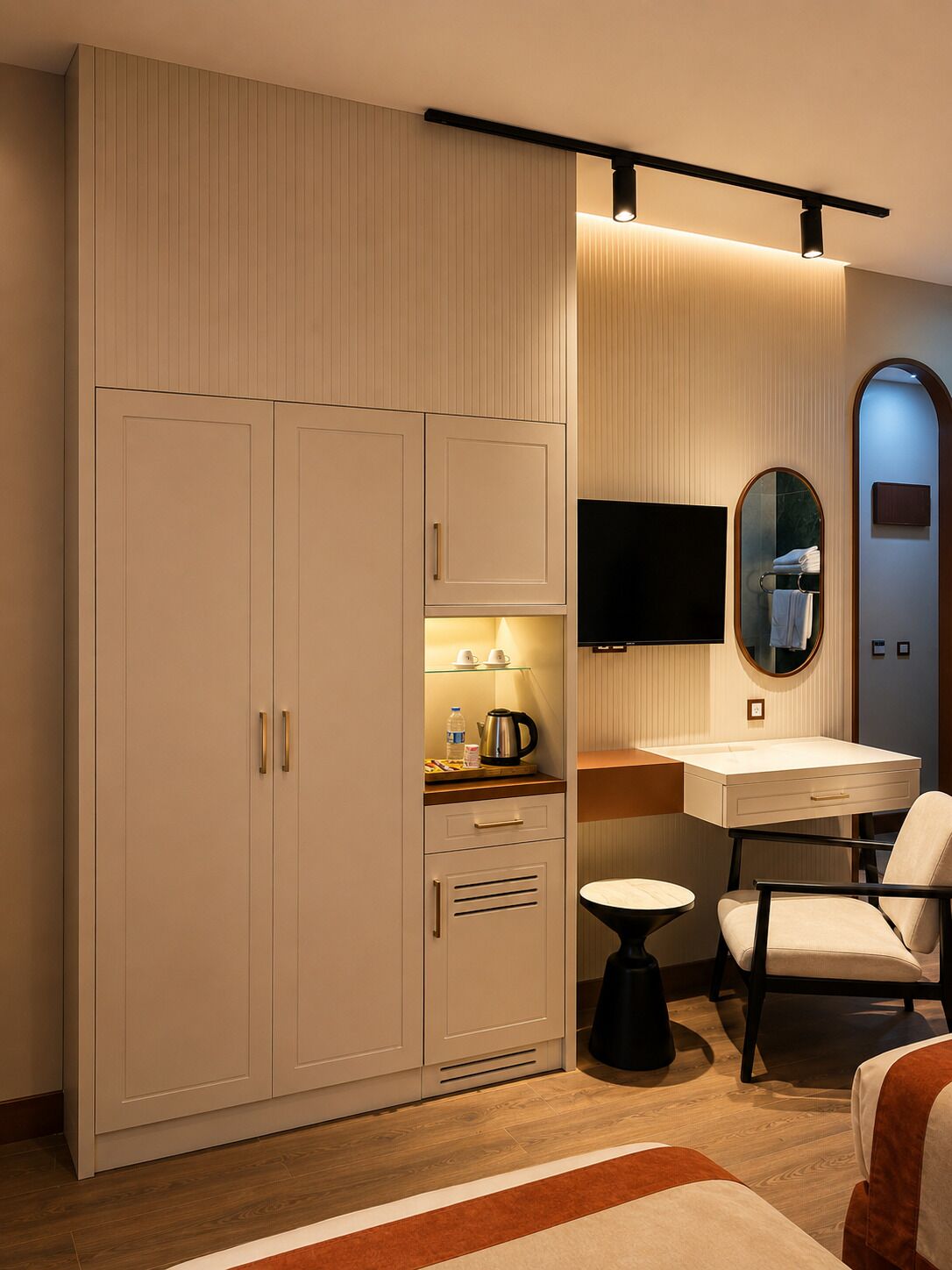 A modern bedroom with a large wardrobe, a bedside table, a chair, and a flat-screen TV mounted on the wall.