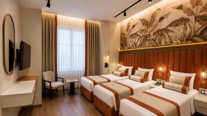 Ein Hotelzimmer mit zwei Betten, einem Schreibtisch, einem Sessel, einem Fernseher und einer großen Wandmalerei.