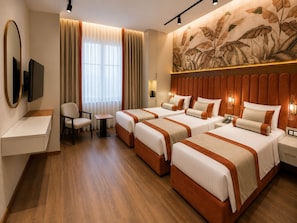 Een hotelkamer met twee bedden, een bureau, een stoel, een televisie en een groot wanddecor.