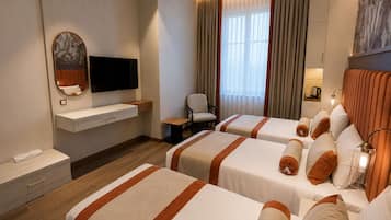 A hotel room with two beds, a TV, a desk, and a chair.