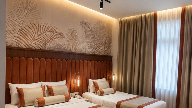 Ein Hotelzimmer mit zwei Betten, einem Holzkopfende, einem Schreibtisch und einem Stuhl.