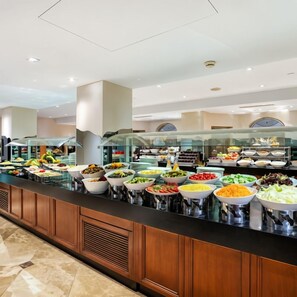 A buffet with various food items and a glass partition. - Ahura Otel (Diyarbakir)