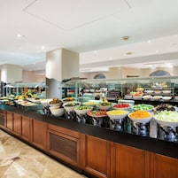 A buffet with various food items and a glass partition.