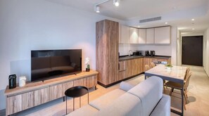 Uma sala de estar moderna com televisão de tela plana, um sofá e uma mesa de centro.
