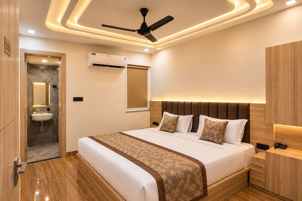 A modern bedroom with a large bed, bedside tables, a ceiling fan, and an air conditioning unit.