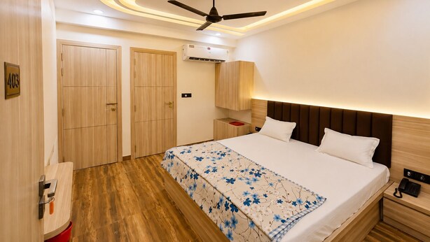 Una habitación de hotel moderna con cama, mesita de noche y ventilador de techo.