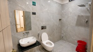 Un baño moderno con lavamanos, inodoro y ducha de mármol.