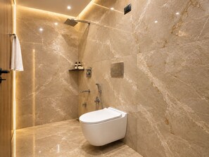 A modern bathroom with a shower, toilet, and marble walls. - Hotel Akrati Inn Vrindavan (Mathura)