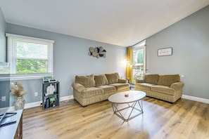 A living room with two sofas, a coffee table, and a TV on a stand.