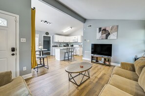 A modern living room with a flat-screen TV, a coffee table, and a sofa.