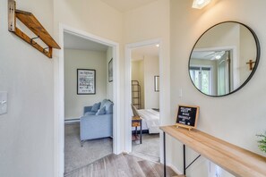 A hallway leading to a bedroom with a bed, a framed map, and a welcome sign. - Blue Sky Retreat w/ 3rd-floor Mtn Views, Starlink (Bailey)