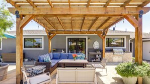 A covered patio with outdoor furniture, a grill, and a clock on the wall. - Napa Extended Stay: Private Pool, Garage Parking! (Napa)