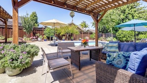 An outdoor patio with a pergola, seating, a pool, and potted plants. - Napa Extended Stay: Private Pool, Garage Parking! (Napa)