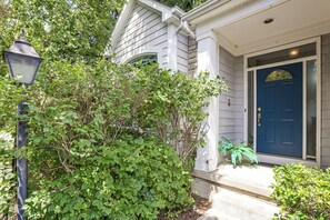 A house with a blue door, a porch, and a street lamp.