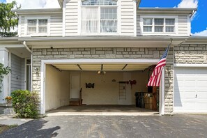 A two-story house with a garage entrance, stone facade, and an American flag. - Lake Views & Work Spaces: Quiet Hilliard Home! (Hilliard)