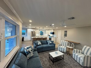 Uma sala de estar moderna com um sofá, uma mesa de centro e uma poltrona listrada.