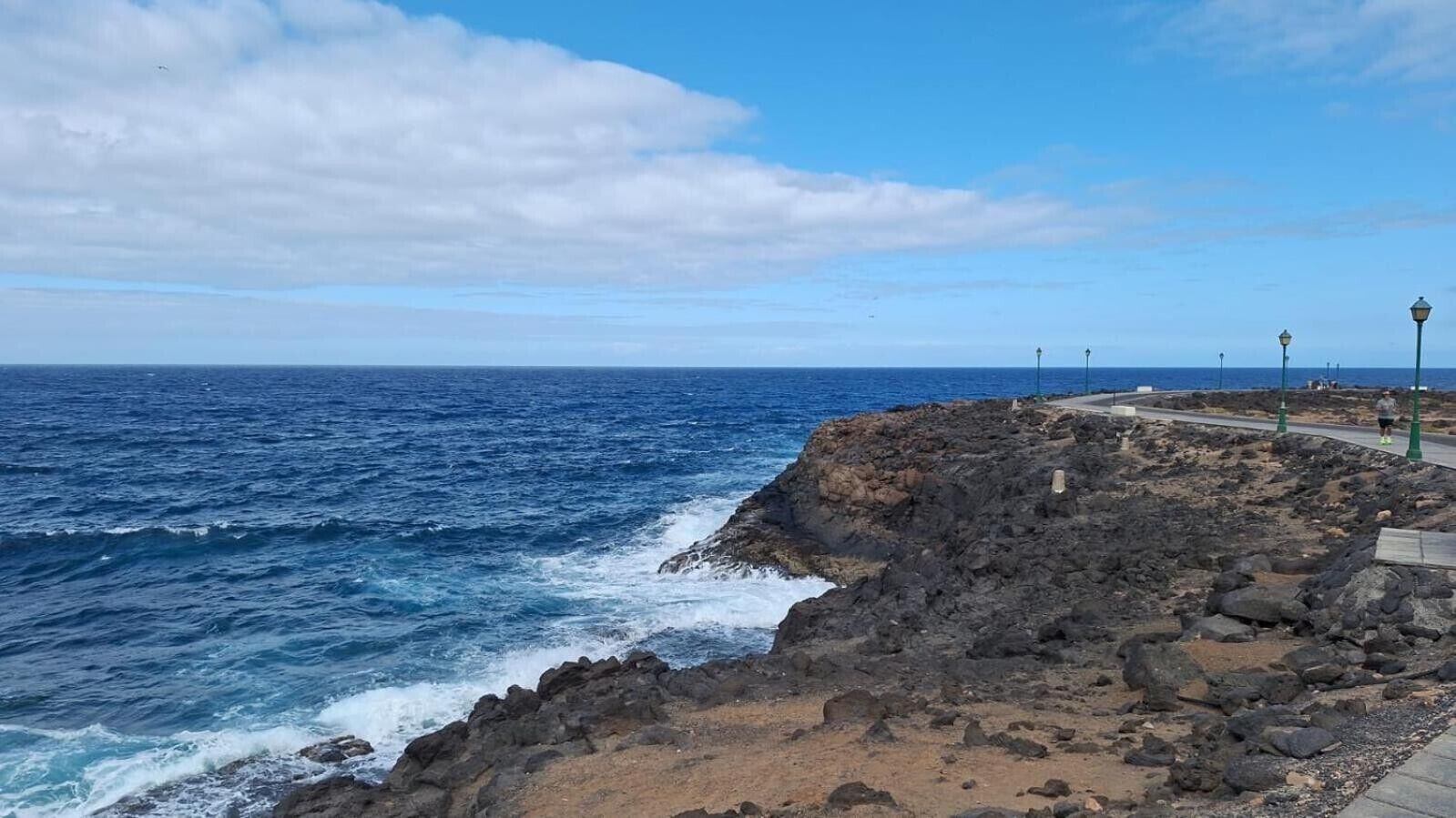 Costa rocosa con un paseo pavimentado y farolas.