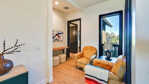 A modern living room with a sofa, a chair, a table, and a view through a window. - Golf Views, Resort Pool Access! Brasada Ranch Home (Powell Butte)