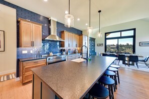 Una cocina moderna con una isla grande, armarios de madera y vistas al exterior.