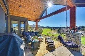 Un espacio de estar al aire libre cubierto con vistas a un campo de golf.