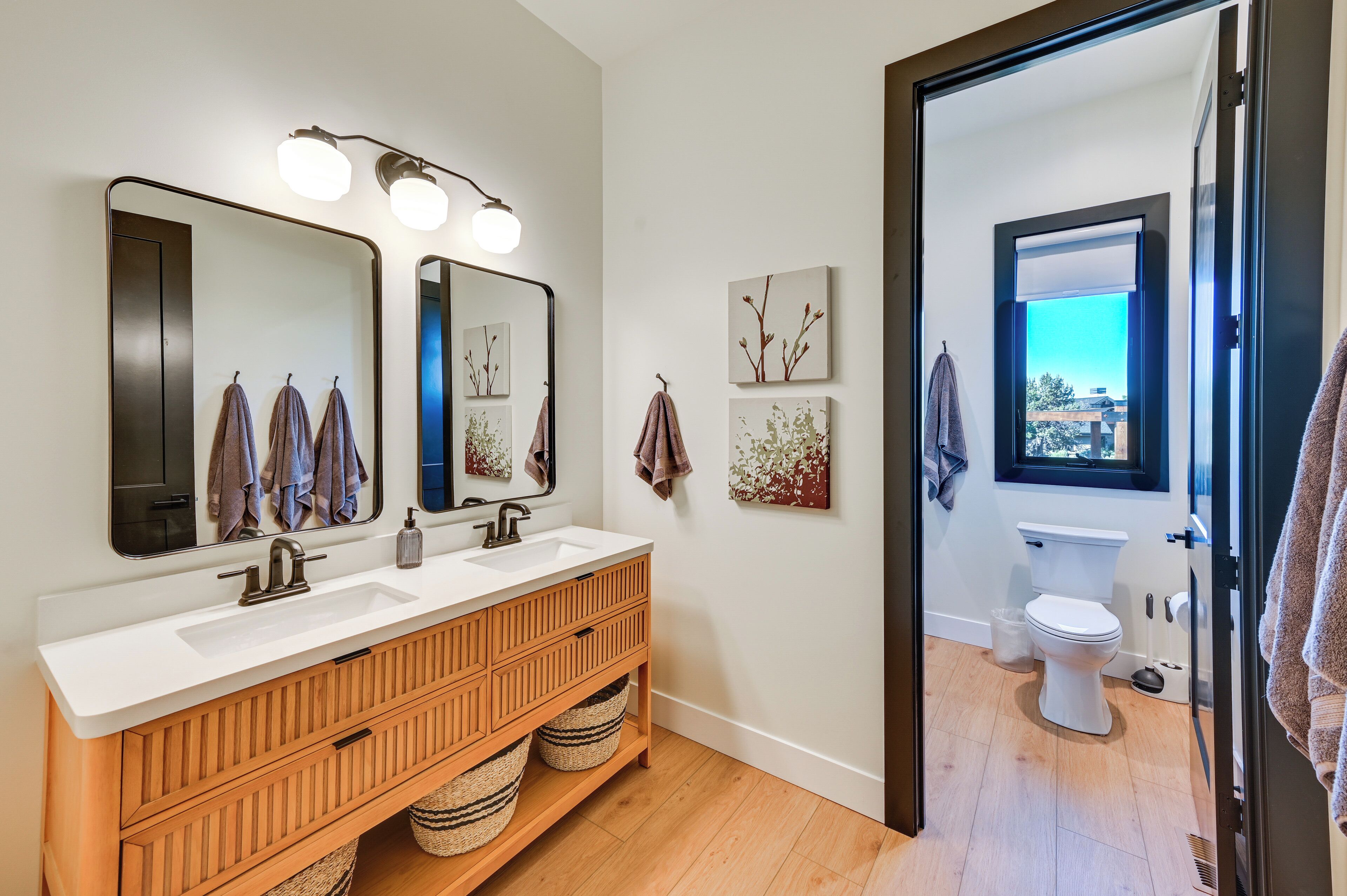 Une salle de bain moderne avec un meuble-lavabo double, des meubles en bois et un grand miroir.