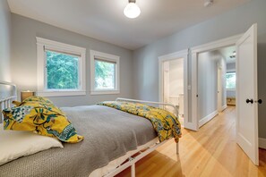 A bedroom with a bed, two windows, a door, and a light fixture. - Walk to Capitol Campus! 'stellar & Bloom Olympia' (Olympia)