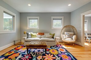 A living room with a sofa, a round chair, a colorful rug, and two windows. - Walk to Capitol Campus! 'stellar & Bloom Olympia' (Olympia)