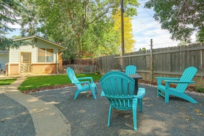 A backyard with a gravel patio, a wooden fence, and a small shed.
