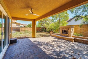 A covered patio area with a stone fireplace, a ceiling fan, and a view of a residential neighborhood. - 3 Mi to Sky River Casino: Elk Grove Getaway (Elk Grove)