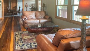 A spacious living room with leather sofas, a glass coffee table, and a patterned rug. - Condo on Lake Hartwell 3 Mi to Clemson Stadium (Seneca)