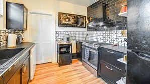 A compact kitchen with a microwave, stove, and refrigerator. - 'the Homecoming Suite' in the Heart of Murray, KY (Murray)