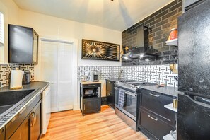 Una cocina compacta equipada con microondas, estufa y refrigerador.