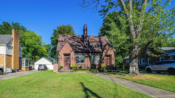 A two-story brick house with a front yard, a garage, and a driveway. - 'the Homecoming Suite' in the Heart of Murray, KY (Murray)