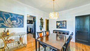 A dining area with a wooden table, chairs, and a chandelier. There is a kitchen visible in the background. - 'the Homecoming Suite' in the Heart of Murray, KY (Murray)