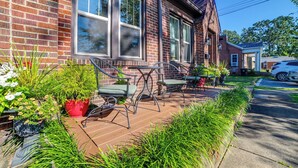 A brick house with a covered porch, two chairs, and potted plants. - 'the Homecoming Suite' in the Heart of Murray, KY (Murray)