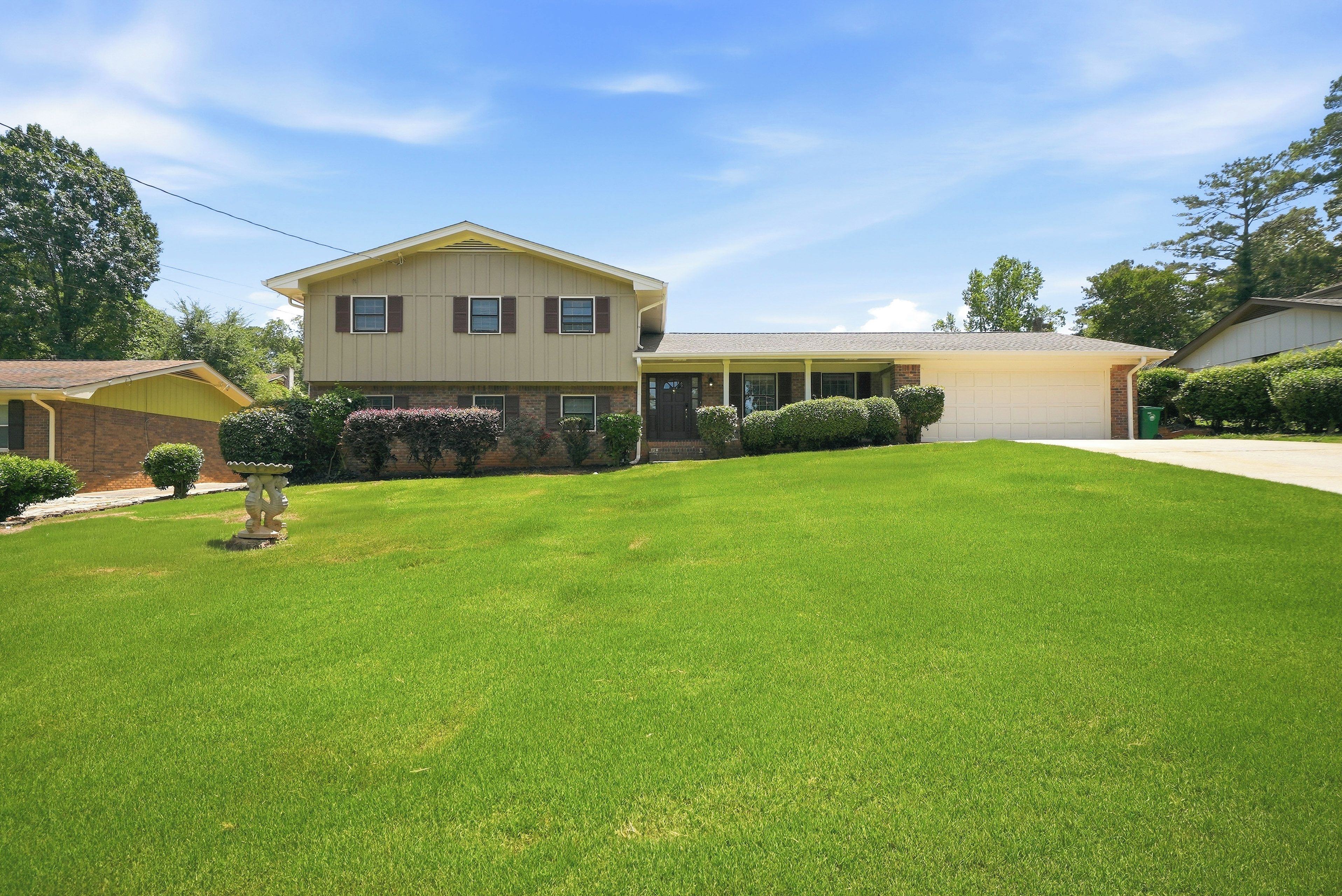 A two-story house with a front lawn and a garage.