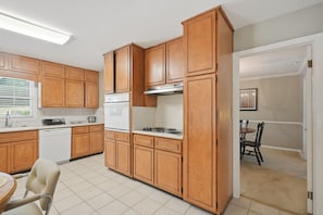 A kitchen with wooden cabinets, a stove, and a dishwasher.
