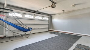 Eine Garage mit einer blauen Hängematte, einem Deckenventilator und einer Garagentür.