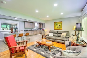 A spacious living area with a sofa, chairs, a coffee table, and a kitchen in the background. - 2 Hot Tubs, Games & Bbqs! Henagar Group Retreat (Henagar)