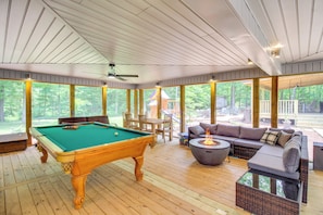 A pool table in a wooden-floored room with large windows, a sofa, and a fire pit. - 2 Hot Tubs, Games & Bbqs! Henagar Group Retreat (Henagar)