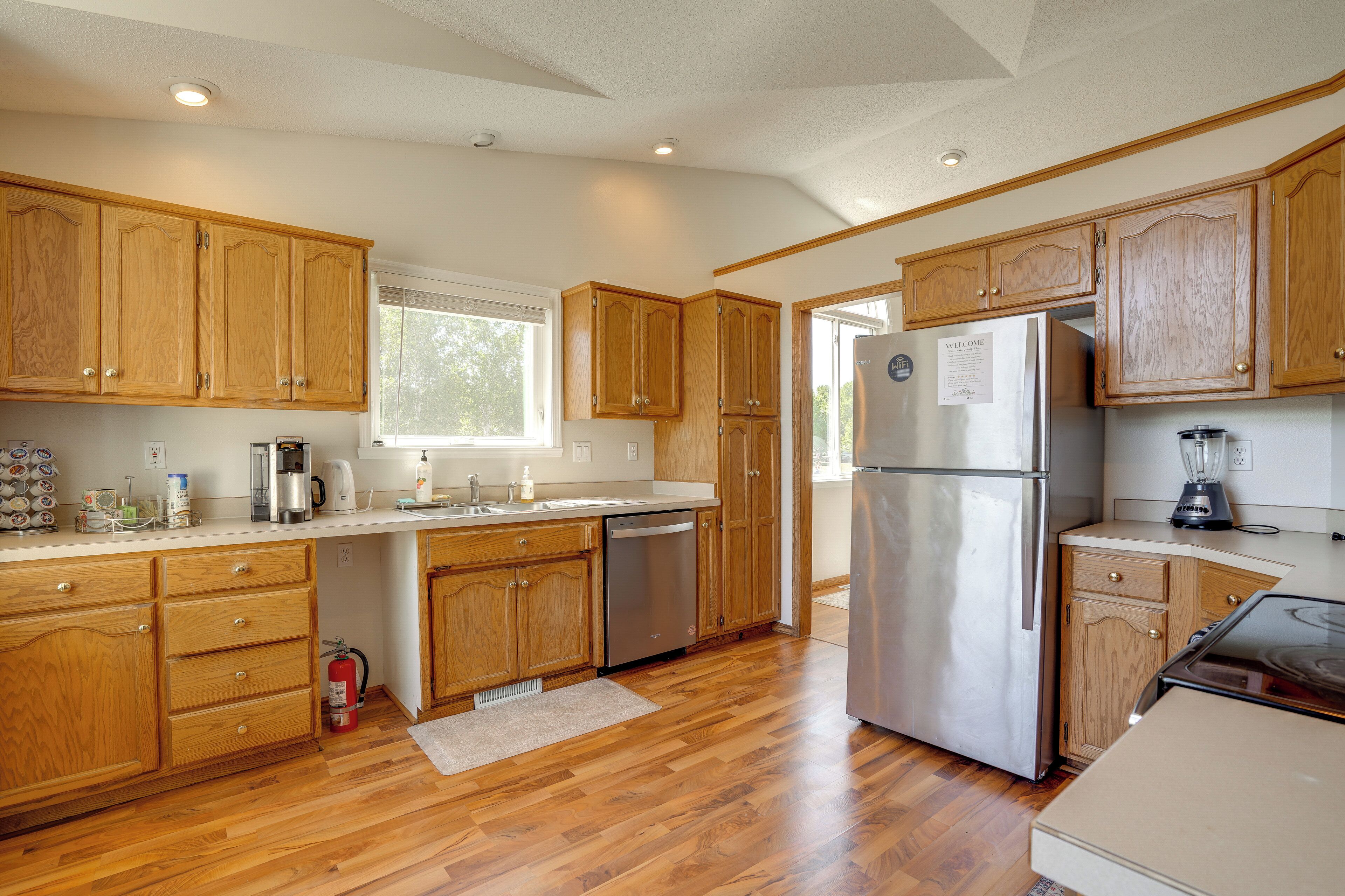 A kitchen with wooden cabinets, stainless steel appliances, and a window providing natural light.