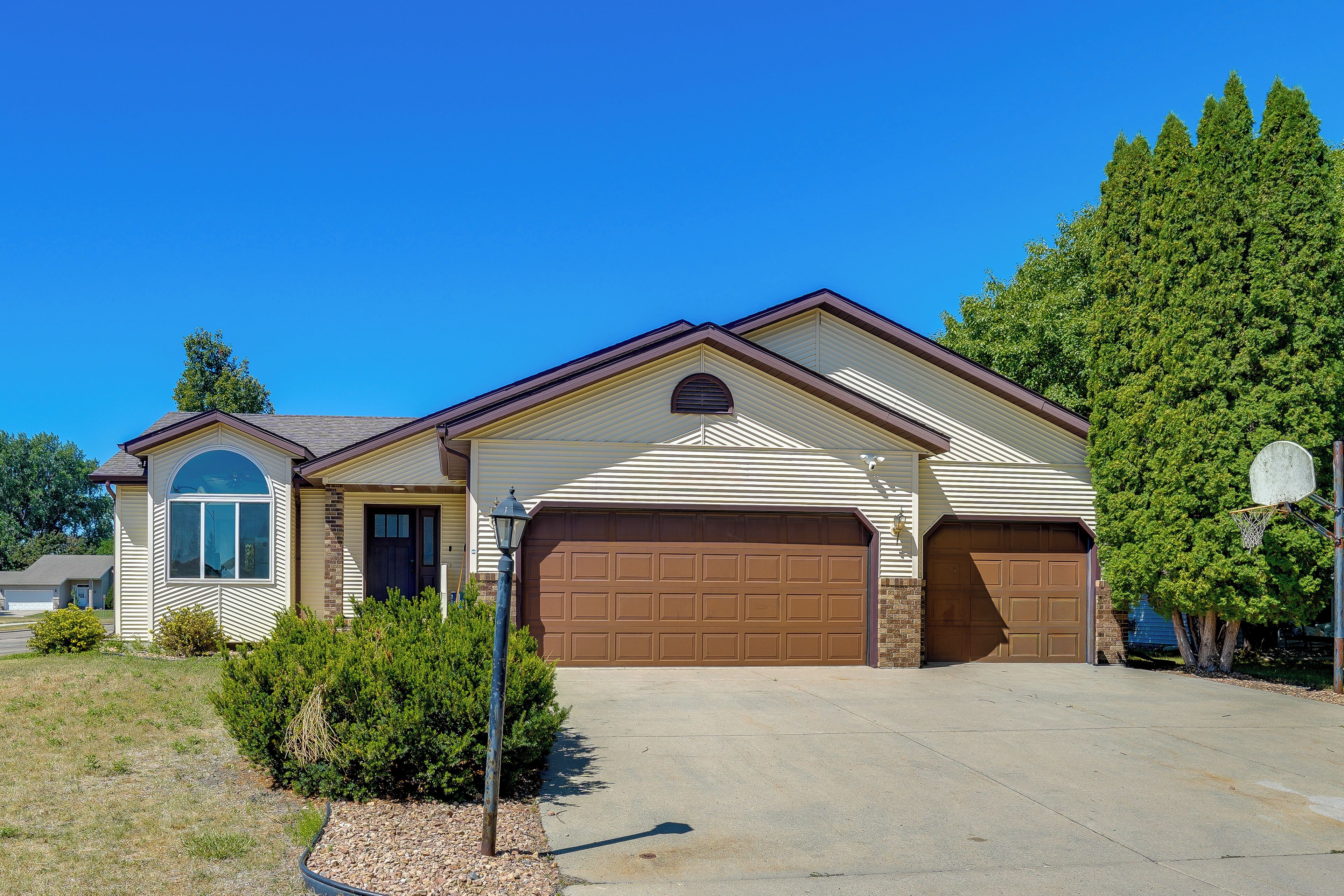 A single-story house with a garage, a small porch, and a well-maintained lawn.