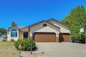 A single-story house with a garage, a small porch, and a well-maintained lawn. - 5BR Home Close to Moorhead Home & Fargo (Moorhead)