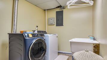 A laundry room with a washing machine, dryer, and a sink.