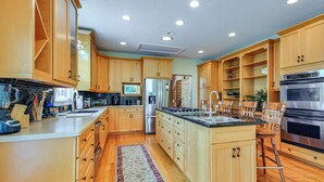 A spacious kitchen with wooden cabinets, stainless steel appliances, and a central island. - Pinnacle Lakefront Retreat: Dock, Canoe & Fire Pit (Pinnacle)