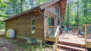 A rustic cabin with a wooden deck and outdoor seating area. - Lakefront Log Cabin w/ Views & Dock in Brandon (Brandon)